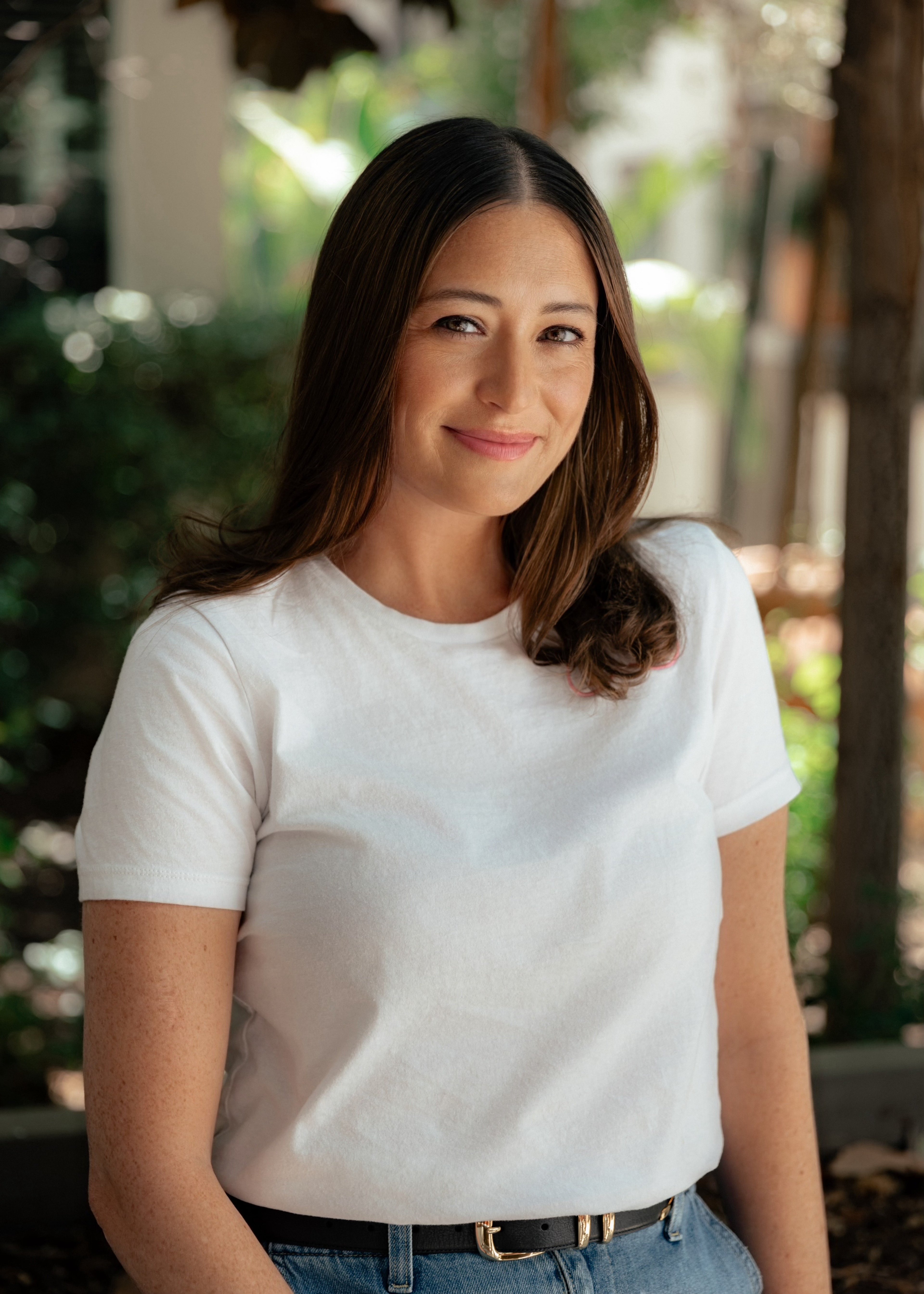 Woman wearing a white t-shirt with a blurred outdoor background